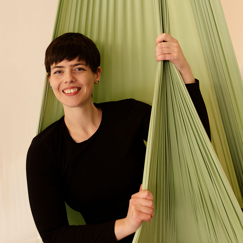 Person mit Aerial Yoga Tuch in glücklicher Pose