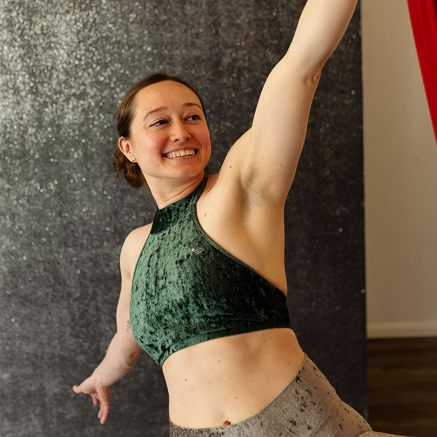 Romina, lächelnd, beim Aerial Yoga.